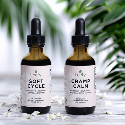 Cramp Calm and Soft Cycle bottles with palm leaves and white flowers