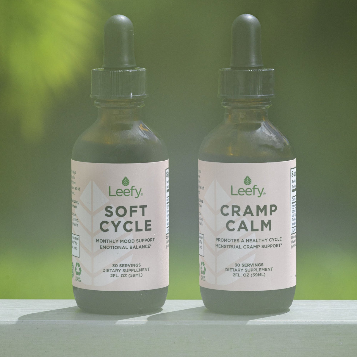 Cramp Calm and Soft Cycle bottles outdoors in greenery